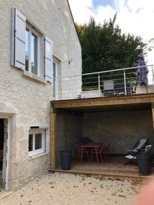 a patio with a red table and chairs on a building at Gite Le petit Relais in Mer