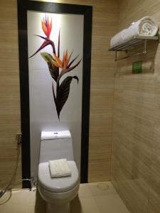 a bathroom with a toilet with a flower painting on the wall at Boracay Haven Suites in Boracay