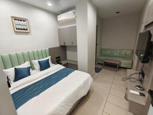 a bedroom with a large bed and a television at Hotel Signature Bopal in Ahmedabad