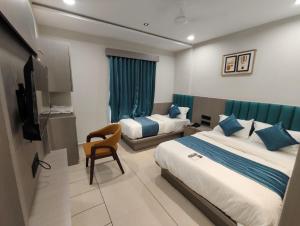 a hotel room with two beds and a television at Hotel Signature Bopal in Ahmedabad
