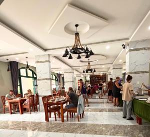 a group of people sitting at tables in a restaurant at My Marina Beach Hotel Phu Quoc in Phú Quốc