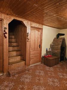 a room with a wooden staircase and a wooden door at Apuseni Wood House in Mătişeşti +15 photos
