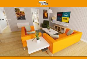 a living room with two orange couches and a table at APPART'HÔTEL Les Prés Blondeau, 1 à 10 personnes, 3 chambres, Terrasse, Parking privé, Wifi, Arrivée autonome 24-7 in Les Rosiers