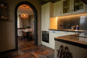 a kitchen with a counter and a table with a dining room at Vakantiewoning de Hofmeier in Benteloo