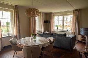 a living room with a couch and a table at Vakantiewoning de Hofmeier in Benteloo
