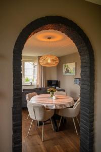 a dining room with a table and a couch at Vakantiewoning de Hofmeier in Benteloo +24 photos