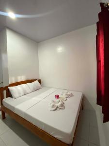 a bedroom with a bed with towels on it at JEHH8 Guest House in Siquijor
