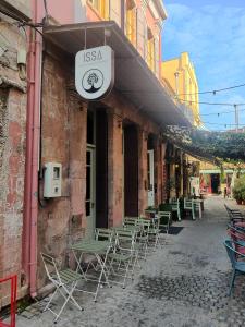 a group of tables and chairs outside of a building at ISSA Lesvos in Mytilene