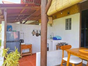 a kitchen with a table and a refrigerator in a room at Pondok Pisces Bungalows Balian Beach in Selemadeg +36 photos