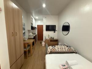a bedroom with a bed and a desk and a dining room at E&J Solace Studio Mactan Bayanihan Flats 2 in Maribago +4 photos
