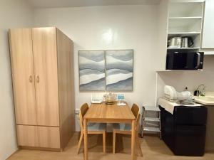 a small kitchen with a wooden table in a room at E&J Solace Studio Mactan Bayanihan Flats 2 in Maribago