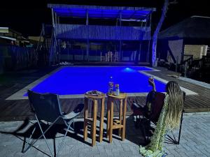 two chairs and a table in front of a swimming pool at MoOs River Lodge in Ntabis