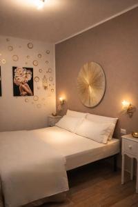 a bedroom with a white bed and a mirror at B&B Nottetempo in Paupisi
