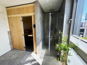 a glass shower door in a building at Penthouse Seeblick am Leuchtturm in Fehmarn