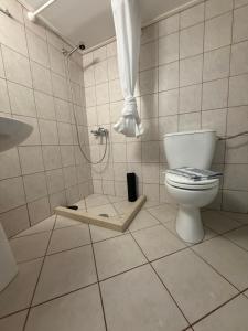 a white bathroom with a toilet and a shower at Sideroporta castle Náfpaktos in Nafpaktos +66 photos