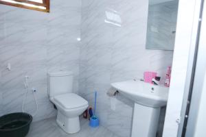 a white bathroom with a toilet and a sink at Annai Agham in Kankesanturai