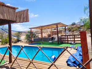 a swimming pool with a table and a pavilion at Casona Mamalluca in El Durazno +12 photos