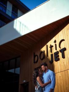 a man and a woman standing in front of a building at Baltic Jet Luxury Aparthotel in Ustronie Morskie