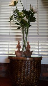 two little statues sitting on a basket with a flower at Ballina Palms Boutique Motel in Ballina