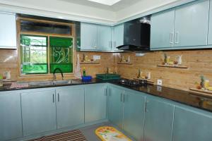 a kitchen with blue cabinets and a window at Annai Agham in Kankesanturai