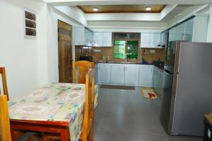 a kitchen with a table and a refrigerator at Annai Agham in Kankesanturai +25 photos