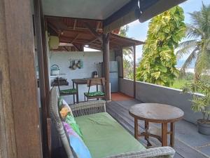 a porch with a table and chairs and a table at Pondok Pisces Bungalows Balian Beach in Selemadeg