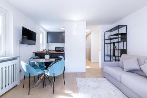 a living room with a couch and a table and chairs at Blanc 4810 in Pré-Saint-Didier