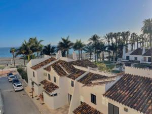 an aerial view of houses with palm trees and the ocean at Terrasol Pirámides Puerto Blanco in Caleta De Velez
