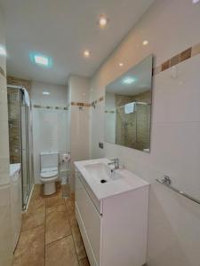 a bathroom with a sink and a toilet and a mirror at Terrasol Pirámides Puerto Blanco in Caleta De Velez +31 photos