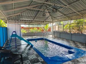 an indoor swimming pool with a canopy and a swimming pool at UDUPI HOMESTAY - Cottage House - Dendoorkatte, Udupi in Udupi