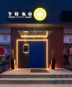 a building with a blue door and a neon sign at Yuko Residence in Jasło