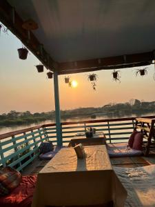 a table on a boat with the sunset in the background at Peace&Love in Ban Sôm