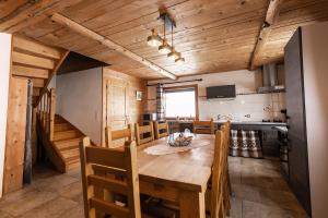 a kitchen and dining room with a wooden table and chairs at Gite du Brin d'Herbe in Pontarlier