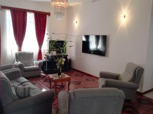 a living room with chairs and a tv on a wall at Karibu Villa Accommodation in Rivière du Rempart