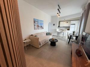 a living room with a couch and a table at White Swallow Suite Santorini in Vourvoúlos +33 photos