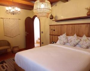 a bedroom with a white bed and a chandelier at Amber Dahabiya in Luxor +7 photos