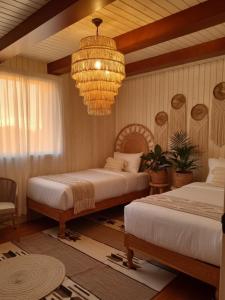 a bedroom with two beds and a chandelier at Amber Dahabiya in Luxor