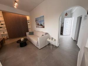 a living room with a couch and a table at White Swallow Suite Santorini in Vourvoúlos