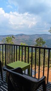 a bench with a table on a balcony with a view at Idukki Nook in Idukki +20 photos