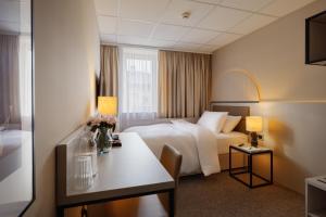 a hotel room with a bed and a table at Yuko Residence in Jasło