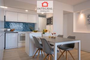 a kitchen with white cabinets and a table and chairs at Palamós Blue Holidays in Palamós