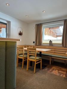 a dining room with a wooden table and chairs at Gästehaus Alpina in Sankt Anton am Arlberg