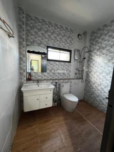 a bathroom with a toilet and a sink and a mirror at Rimkuan Lakeview in Ban Kham Kom