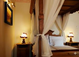 a bedroom with a canopy bed with two lamps at Boutique Hotel ,,Villa Franca'' in Sighişoara +80 photos
