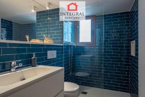 a blue tiled bathroom with a toilet and a sink at Palamós Blue Holidays in Palamós +9 photos