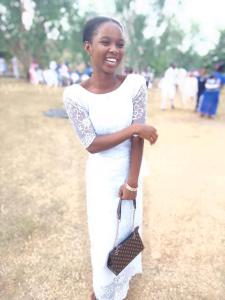 a woman in a white dress holding a purse at Havvina property in Mama