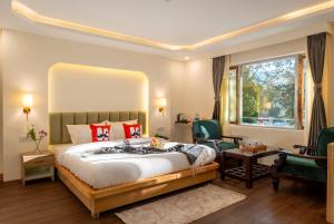 a bedroom with a large bed and a desk and chairs at Moustache Hostel Nainital in Nainital