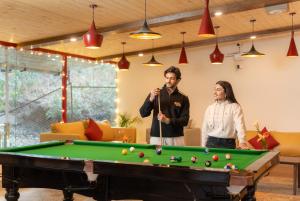 a man and woman standing next to a pool table at Moustache Hostel Nainital in Nainital