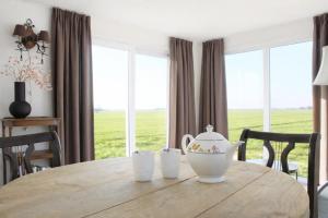a dining room table with a tea pot on top of it at Chalet vrijheid in Tjerkgaast +8 photos