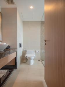 a bathroom with a toilet and a sink and a door at Navada Beach Hotel in Nha Trang